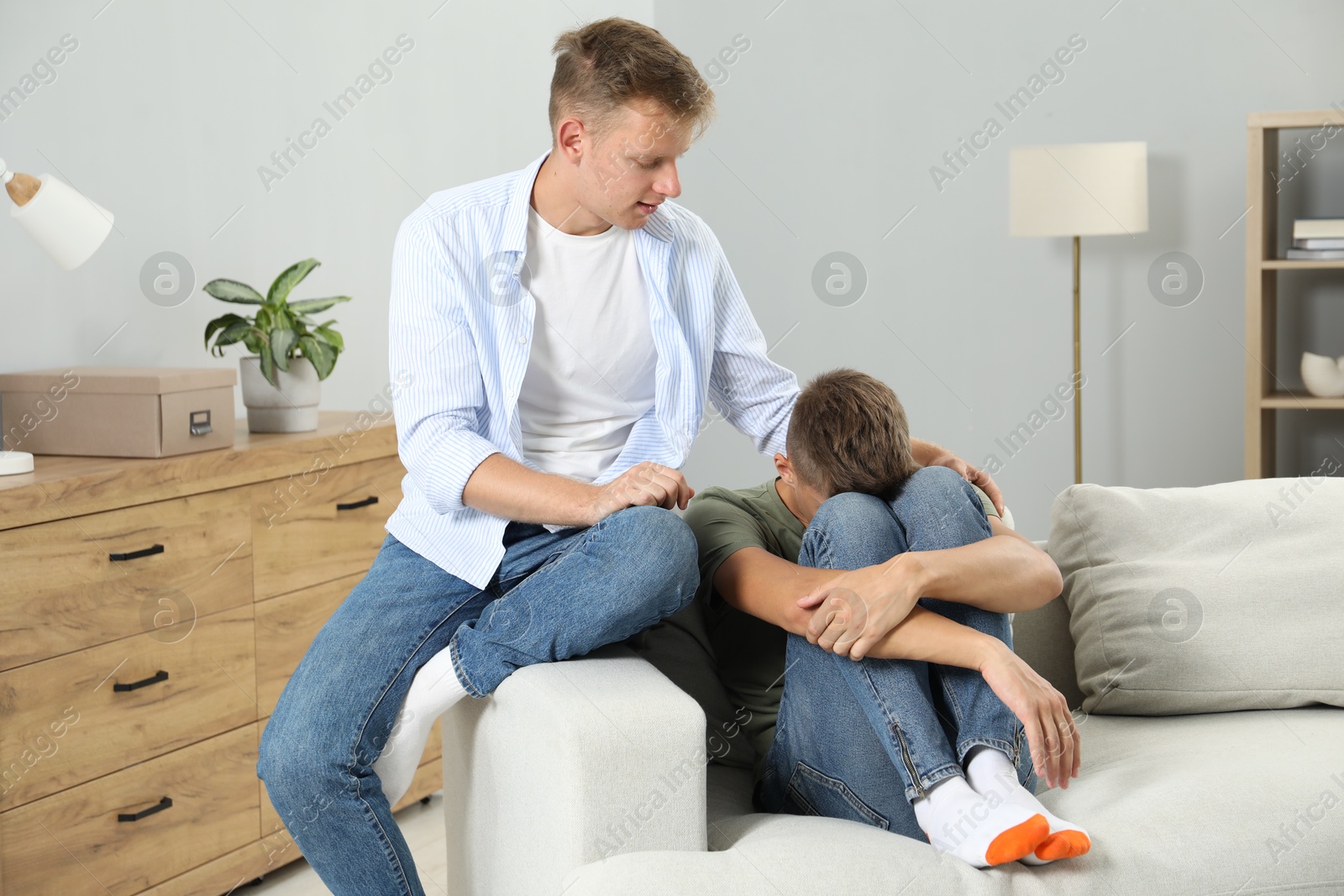 Photo of Young man comforting his brother at home