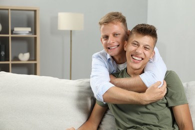 Photo of Happy brothers hugging at home. Space for text