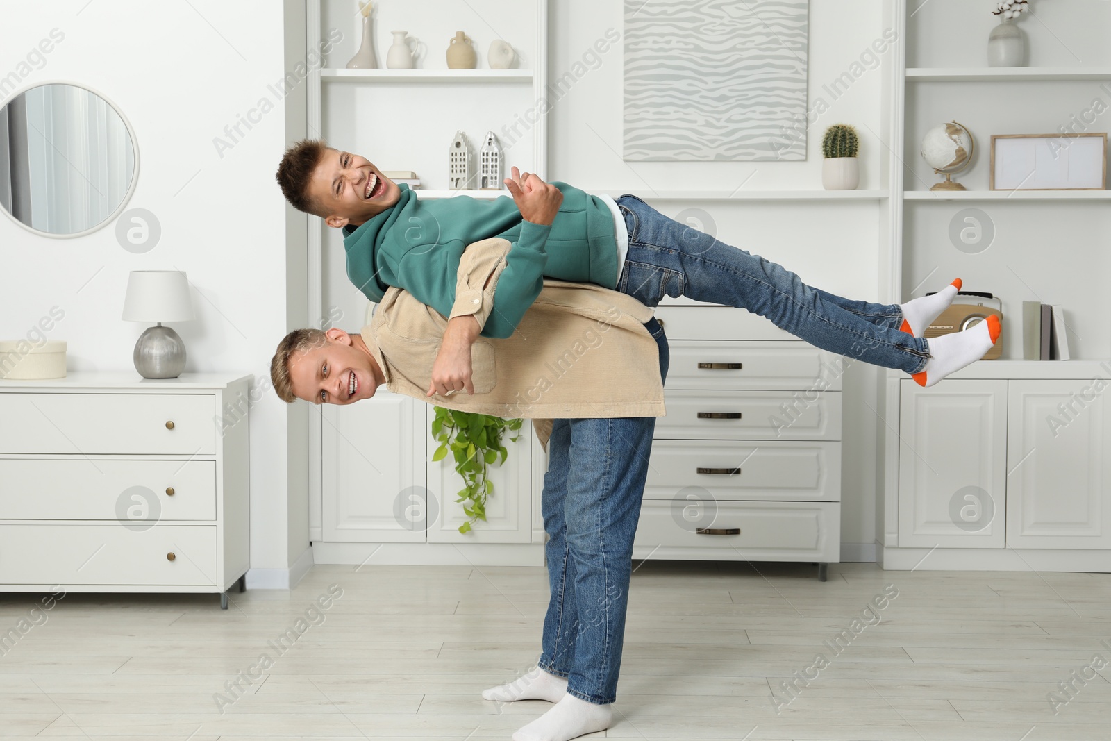 Photo of Full length portrait of happy brothers having fun at home