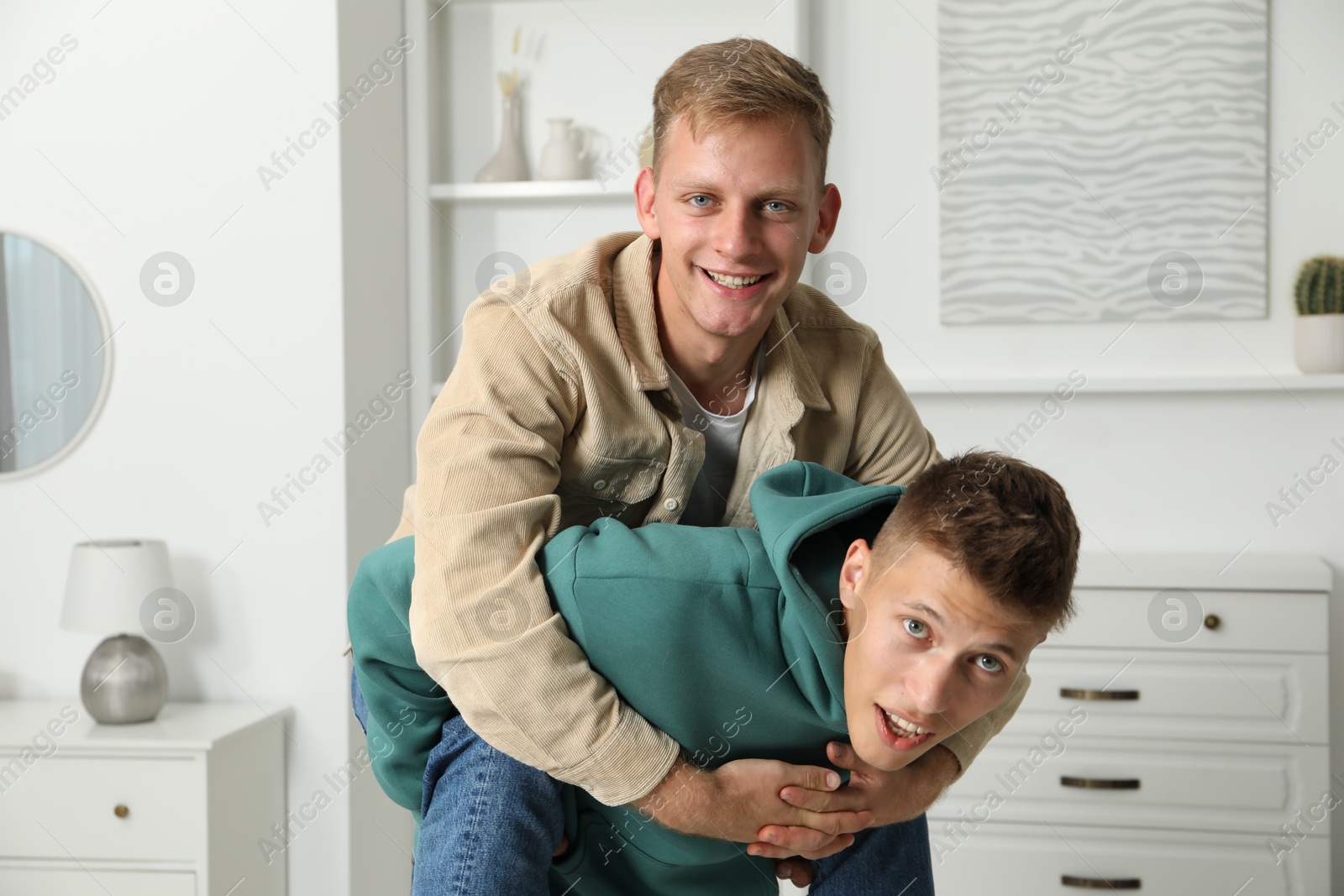 Photo of Family portrait of happy brothers having fun at home