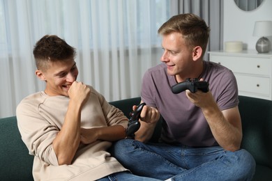 Happy brothers playing video game at home