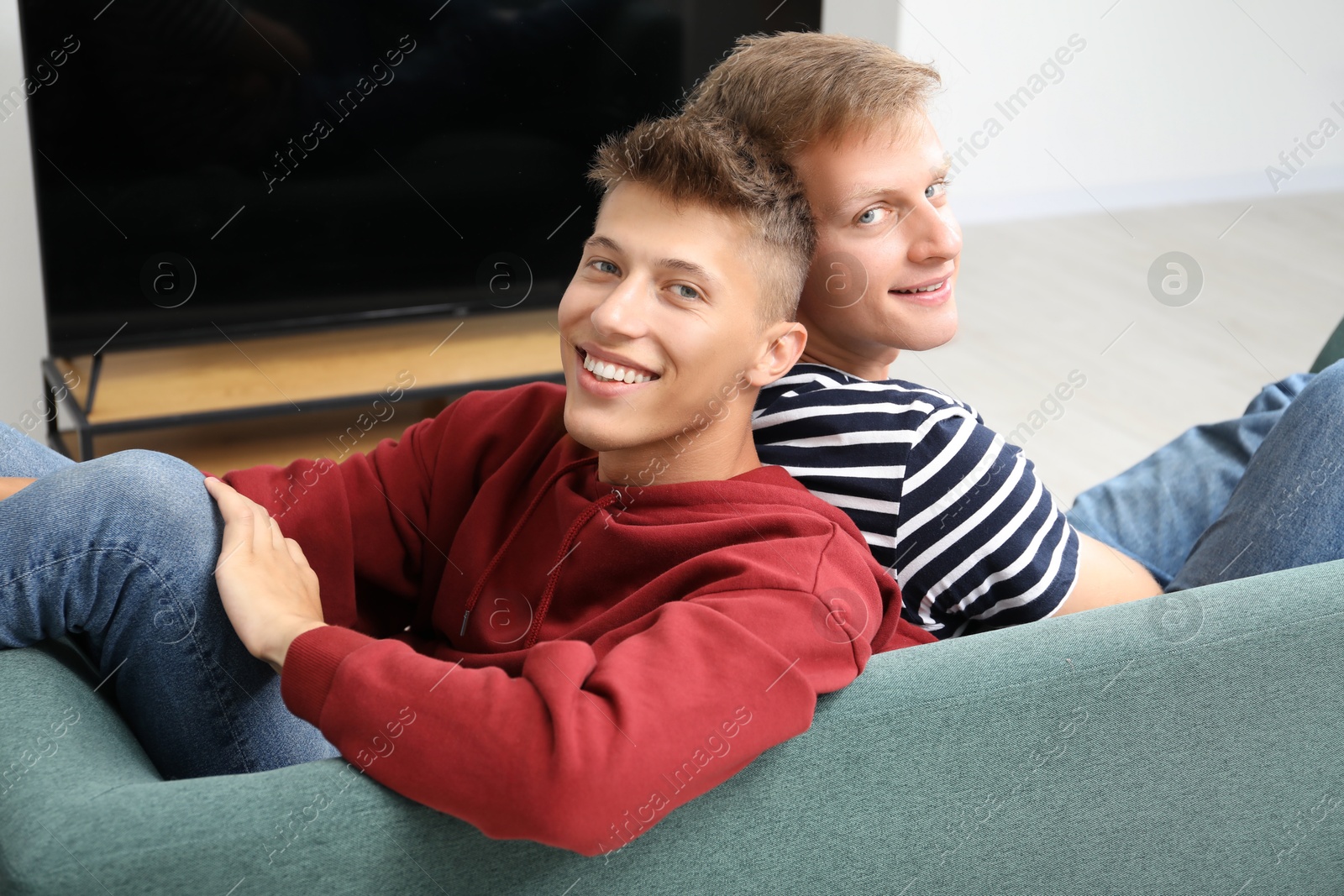 Photo of Family portrait of happy brothers on sofa at home