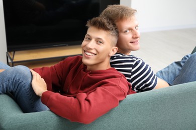 Family portrait of happy brothers on sofa at home