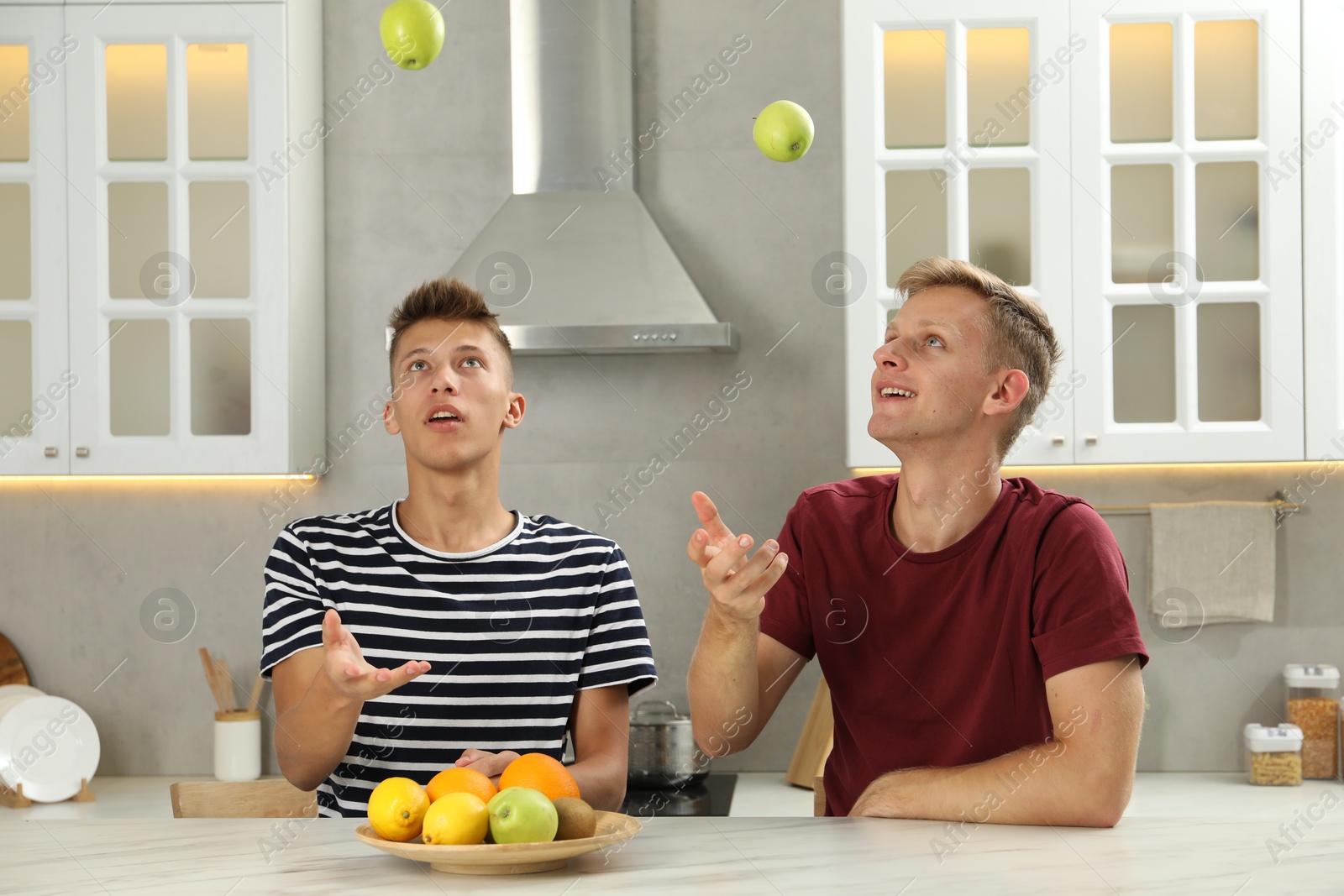 Photo of Happy brothers spending time together in kitchen