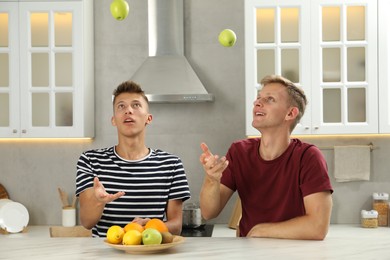 Happy brothers spending time together in kitchen