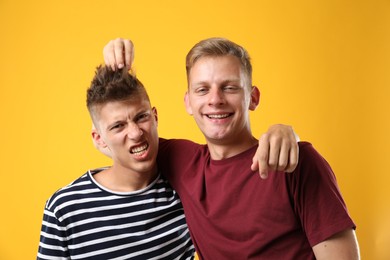 Photo of Portrait of happy brothers on orange background