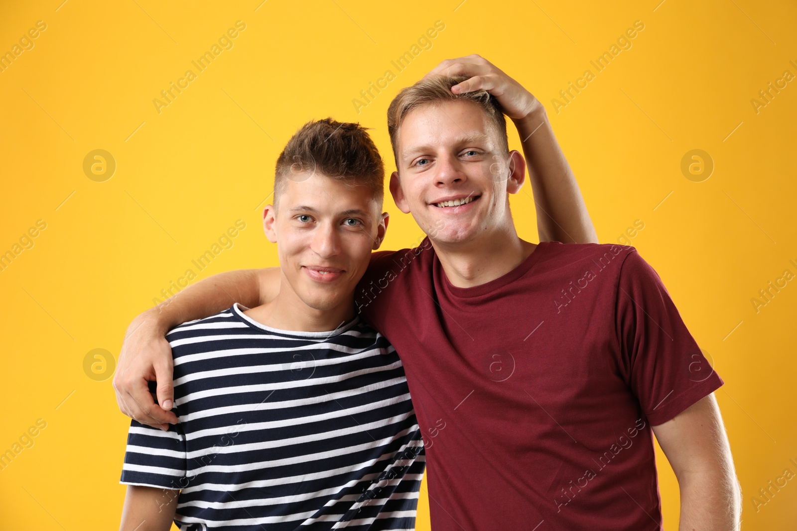 Photo of Portrait of happy brothers on orange background