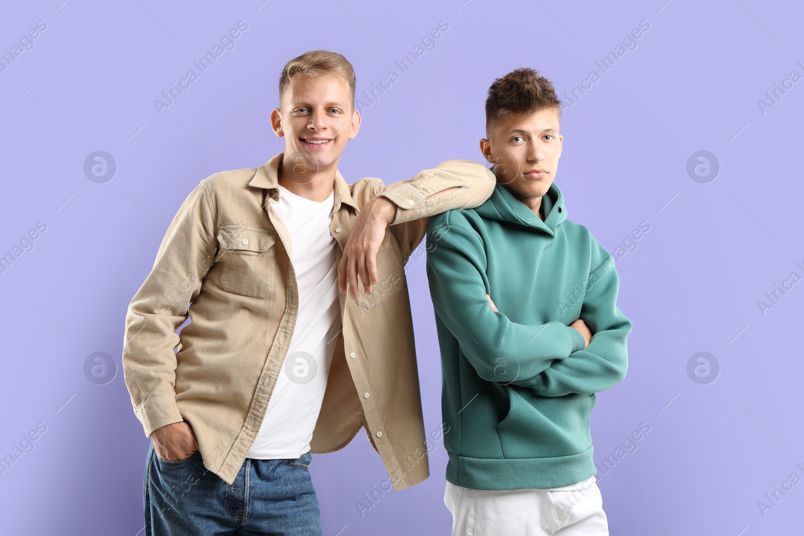 Photo of Portrait of happy brothers on violet background