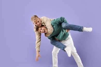 Happy brothers having fun on violet background