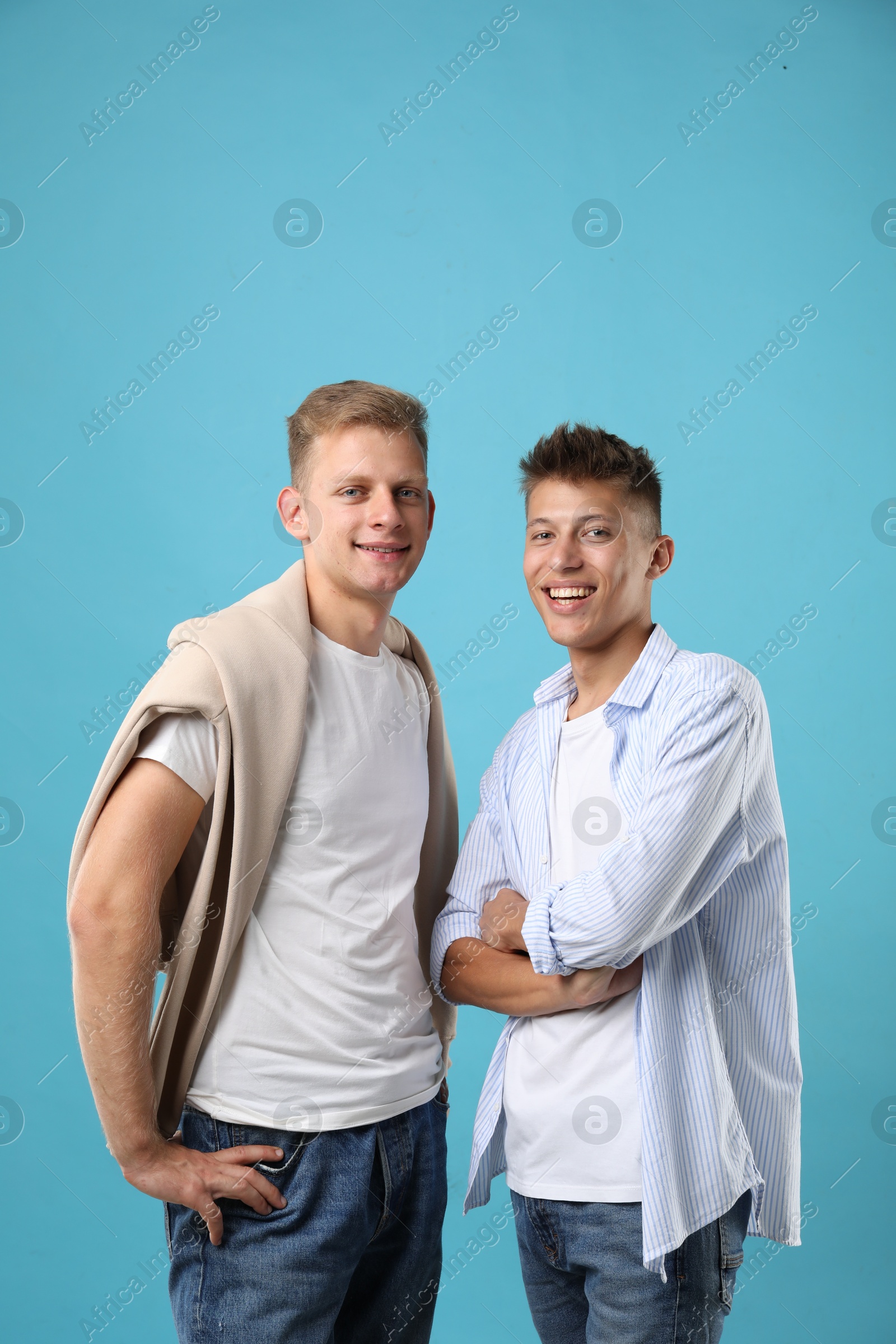 Photo of Portrait of happy brothers on light blue background