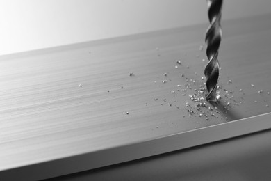 Photo of Drilling hole in plank on light table, closeup