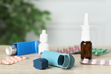 Photo of Different asthma medications on wooden table, closeup