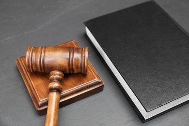 Book and judge's gavel on gray textured table