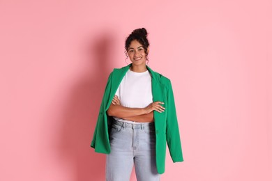 Beautiful woman with stylish jacket on pink background