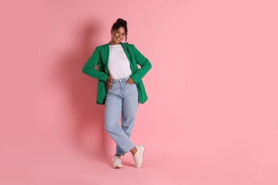 Beautiful woman in stylish jacket on pink background