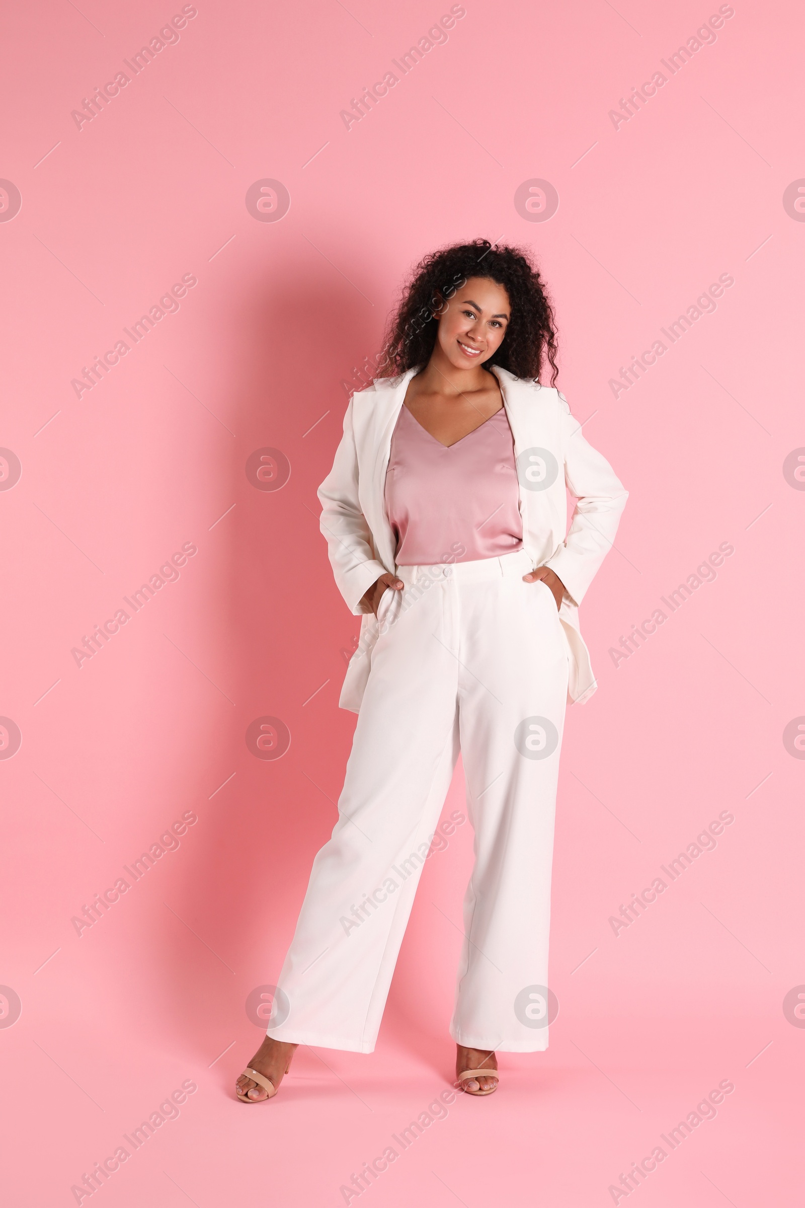 Photo of Beautiful woman in stylish suit on pink background