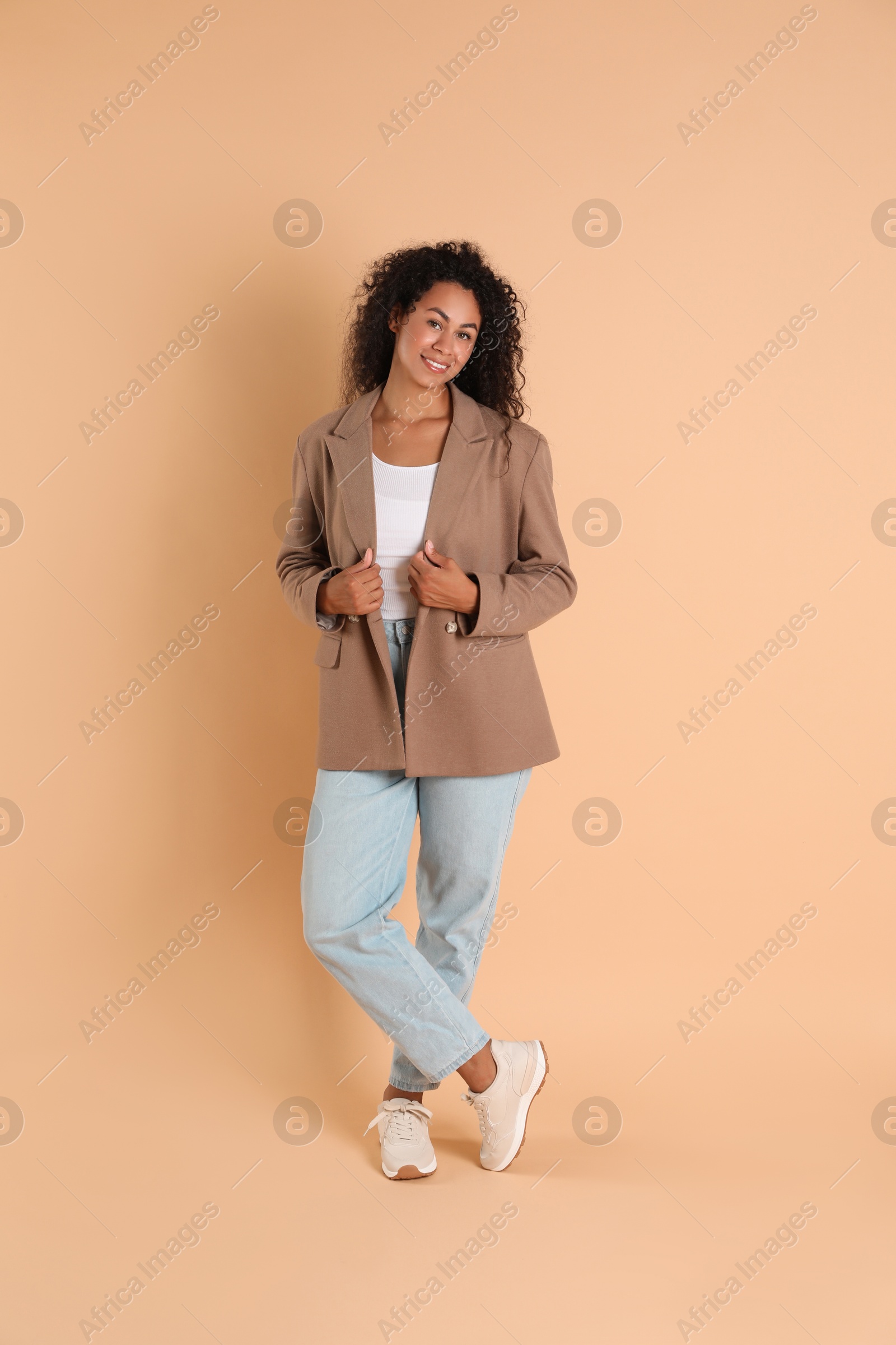 Photo of Beautiful woman in stylish jacket on beige background