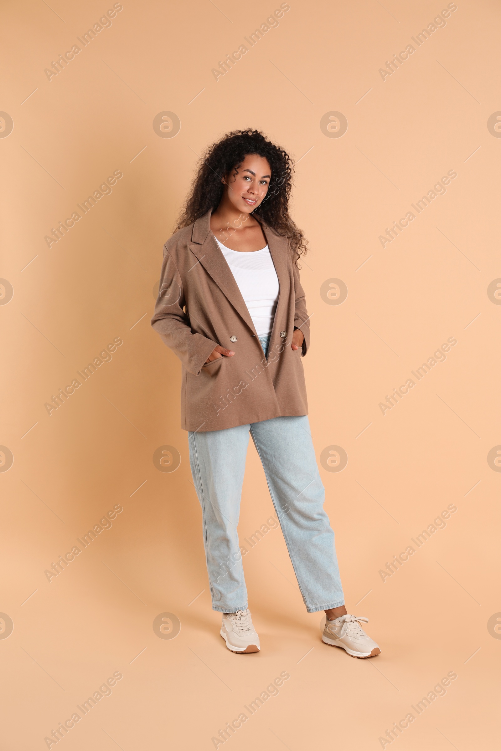 Photo of Beautiful woman in stylish jacket on beige background