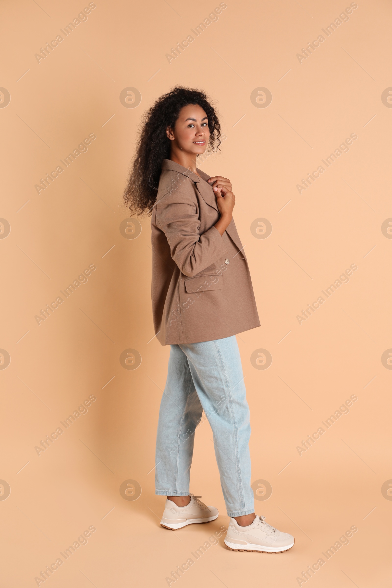 Photo of Beautiful woman in stylish jacket on beige background