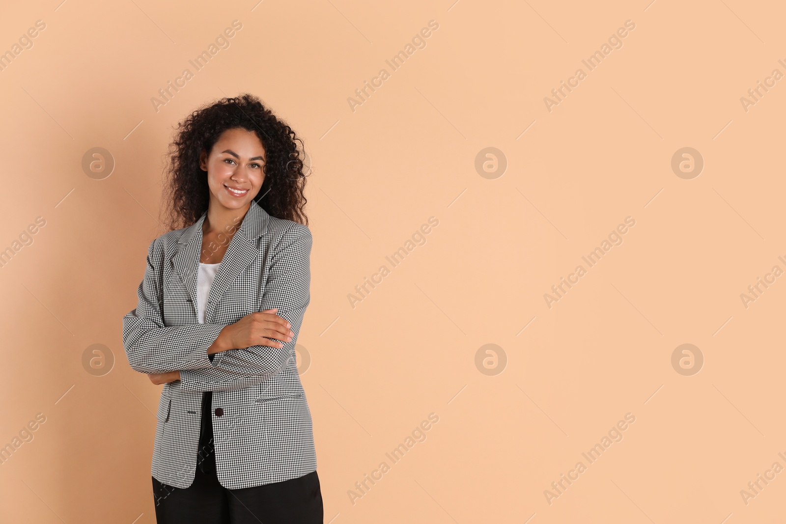 Photo of Beautiful woman in stylish jacket on beige background, space for text