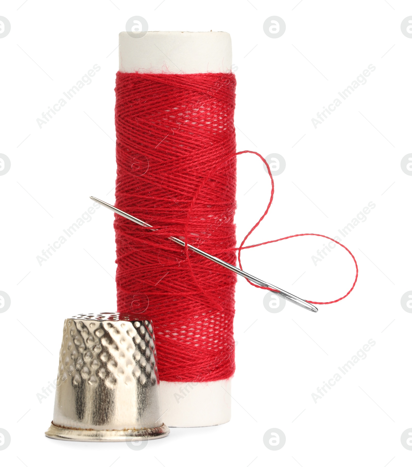 Photo of Thimble and needle with red sewing thread isolated on white