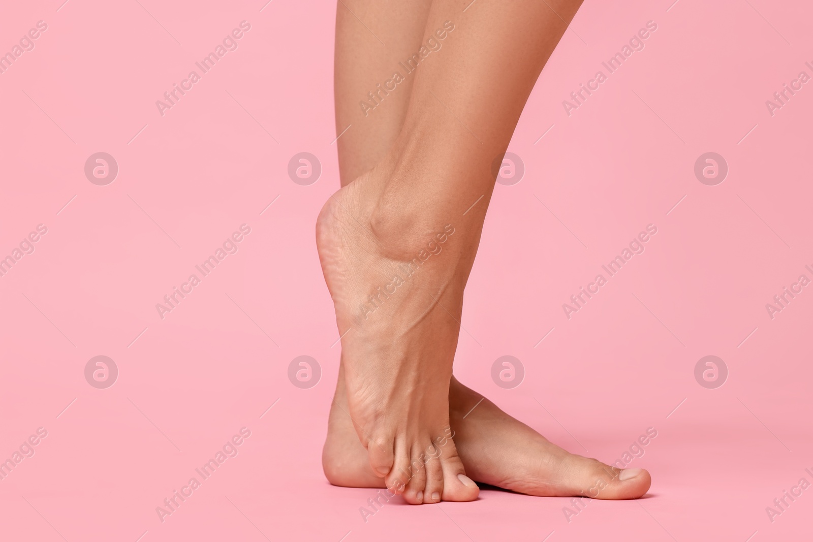 Photo of Woman with smooth feet on pink background, closeup. Space for text