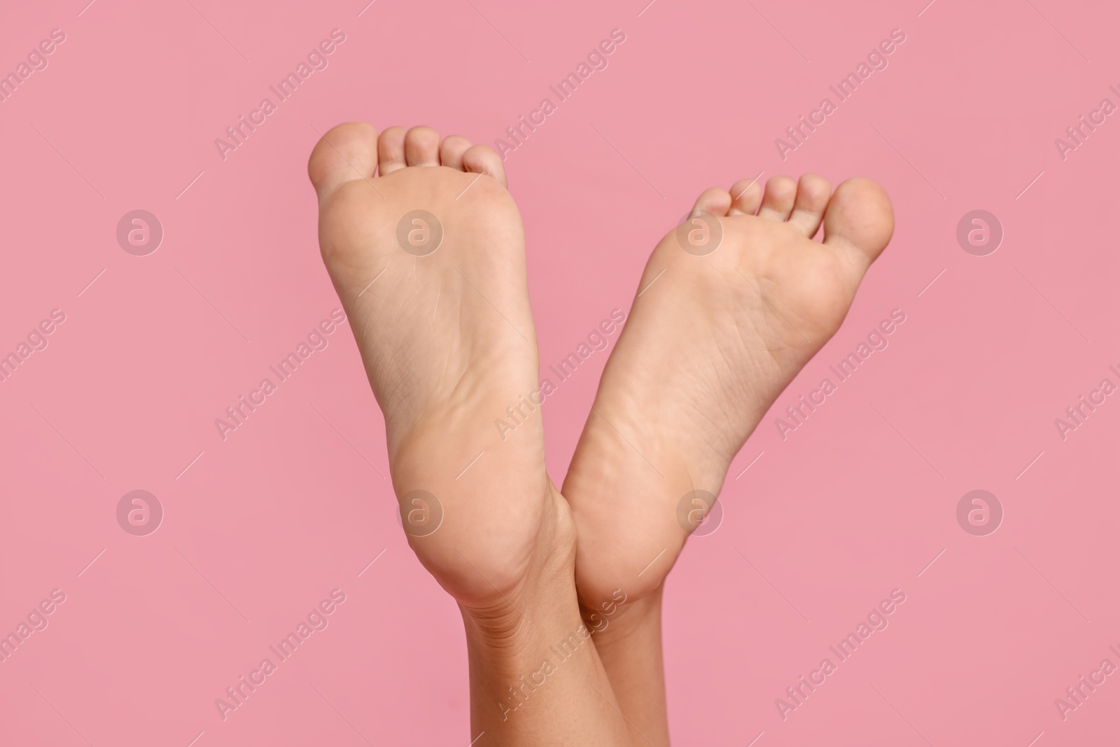 Woman with smooth feet on pink background, closeup Photo of Woman with smooth feet on pink background, closeup