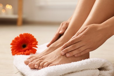 Photo of Woman touching her smooth feet on floor, closeup. Body care