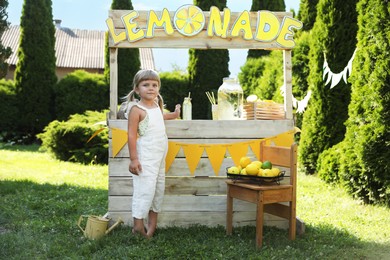 Photo of Little girl near lemonade stand in park