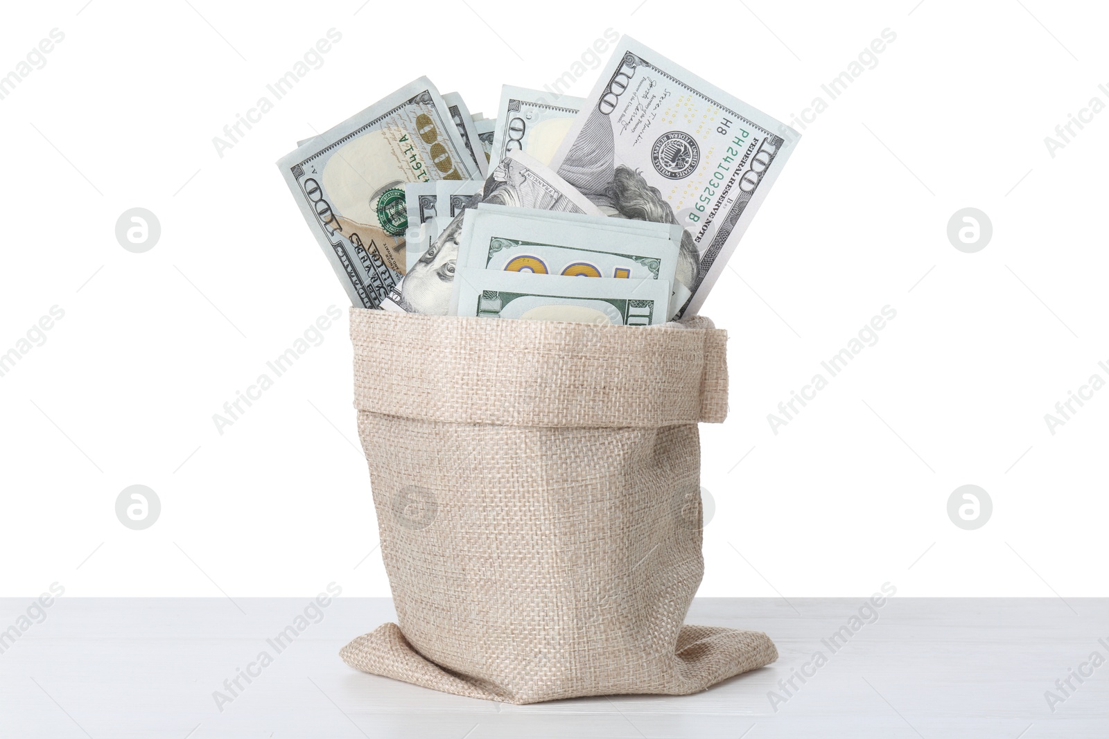 Photo of Dollar banknotes in bag on table against white background