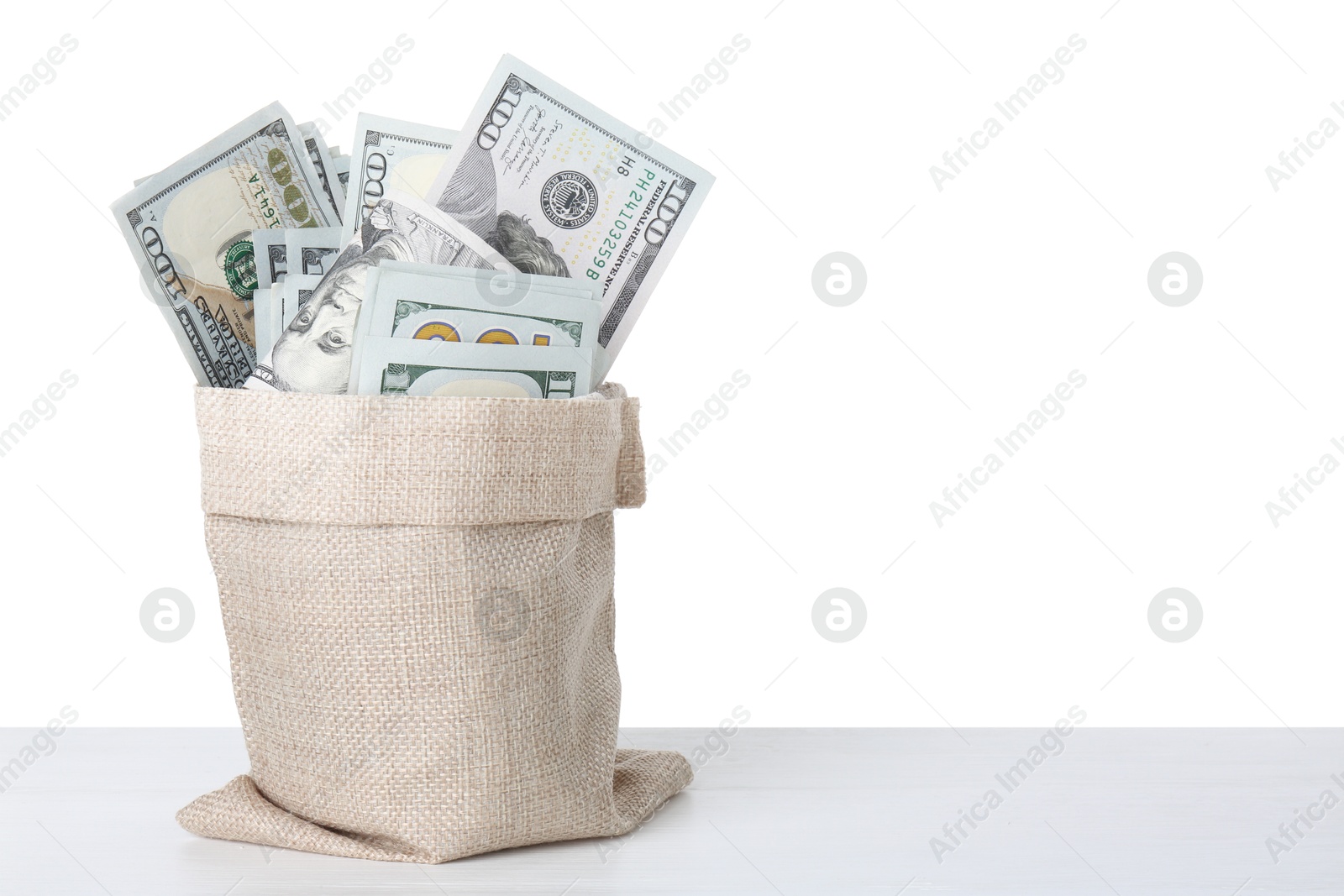 Photo of Dollar banknotes in bag on table against white background, space for text