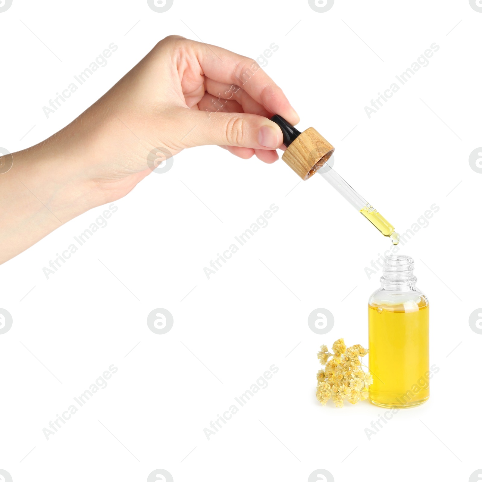 Photo of Woman dripping tincture from pipette into bottle on white background, closeup