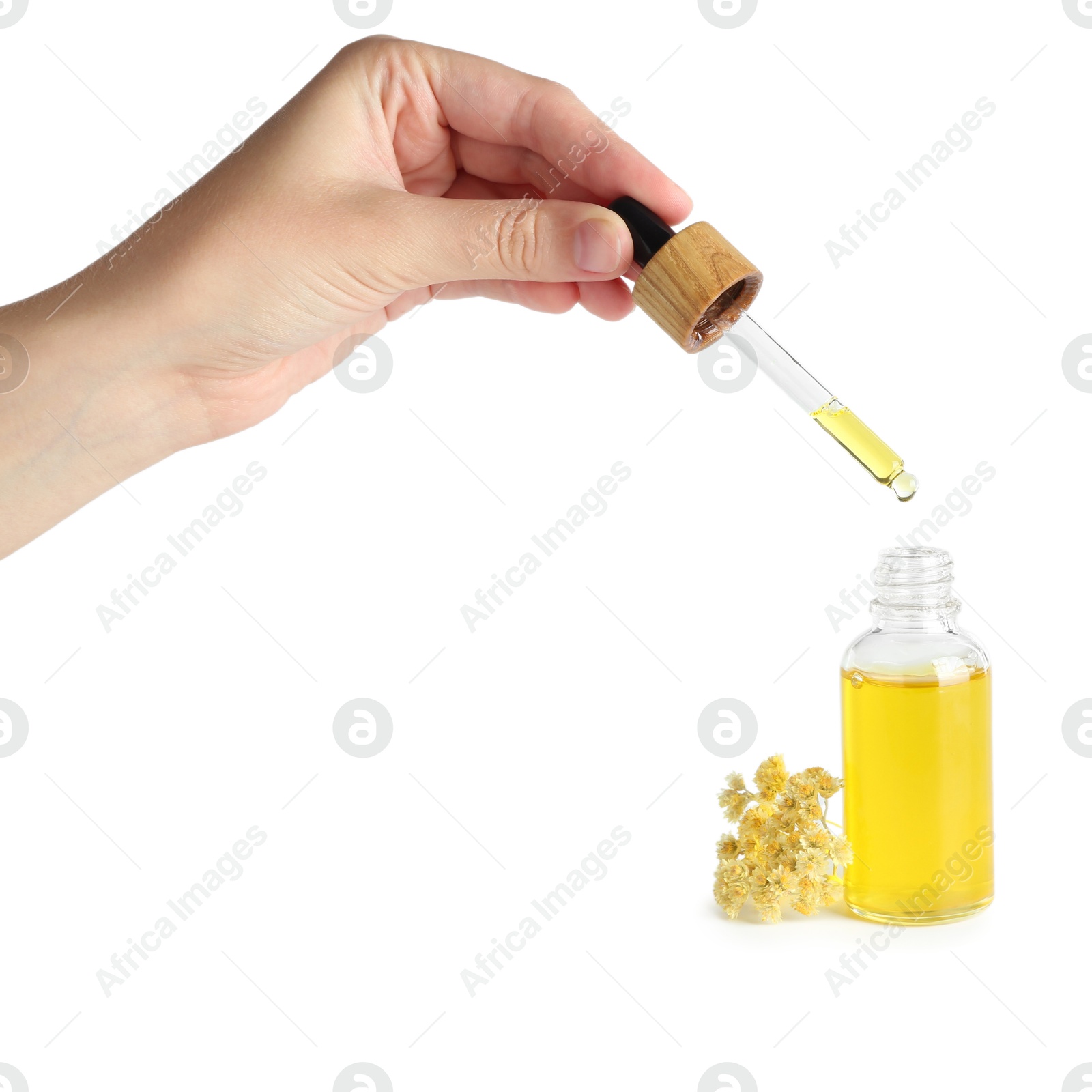 Photo of Woman dripping tincture from pipette into bottle on white background, closeup