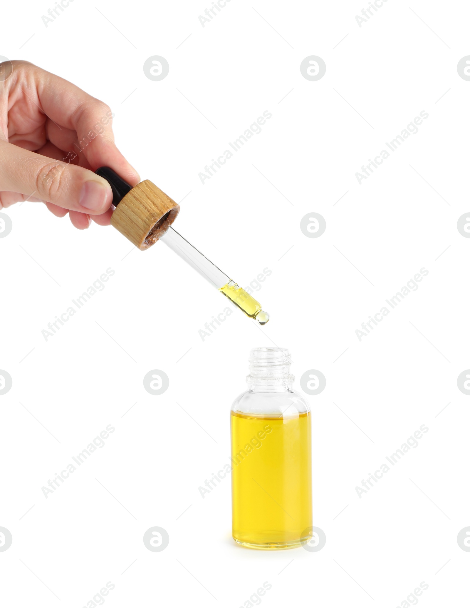 Photo of Woman dripping tincture from pipette into bottle on white background, closeup