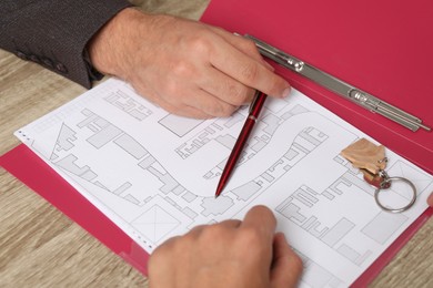 Photo of Real estate agent working with client at wooden table, closeup