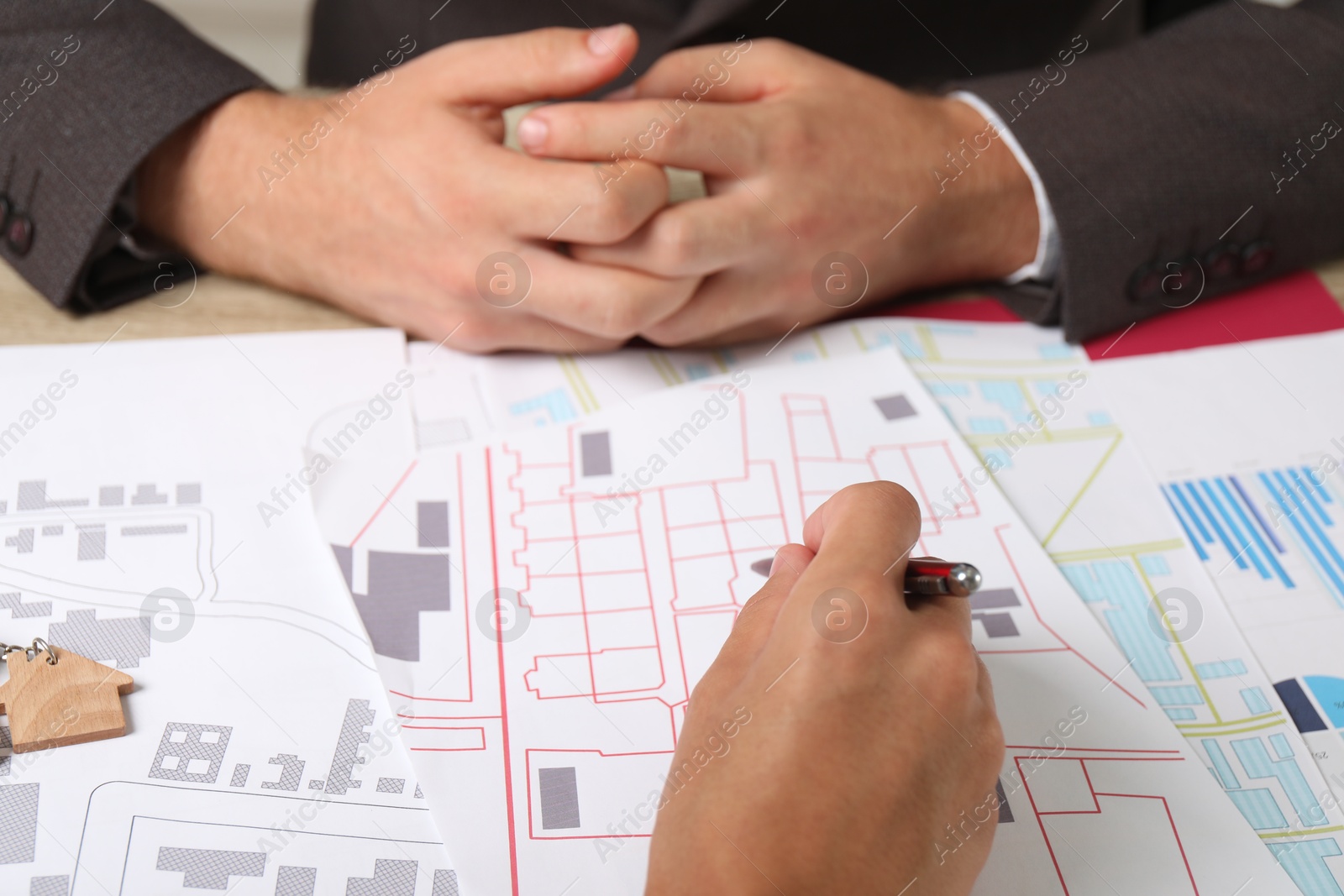 Photo of Real estate agent working with client at table, closeup