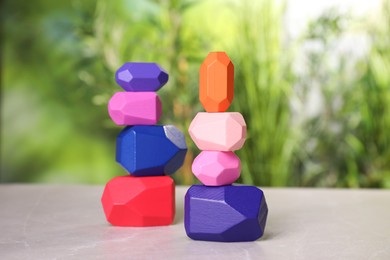 Photo of Many colorful balancing stones on light grey outdoors