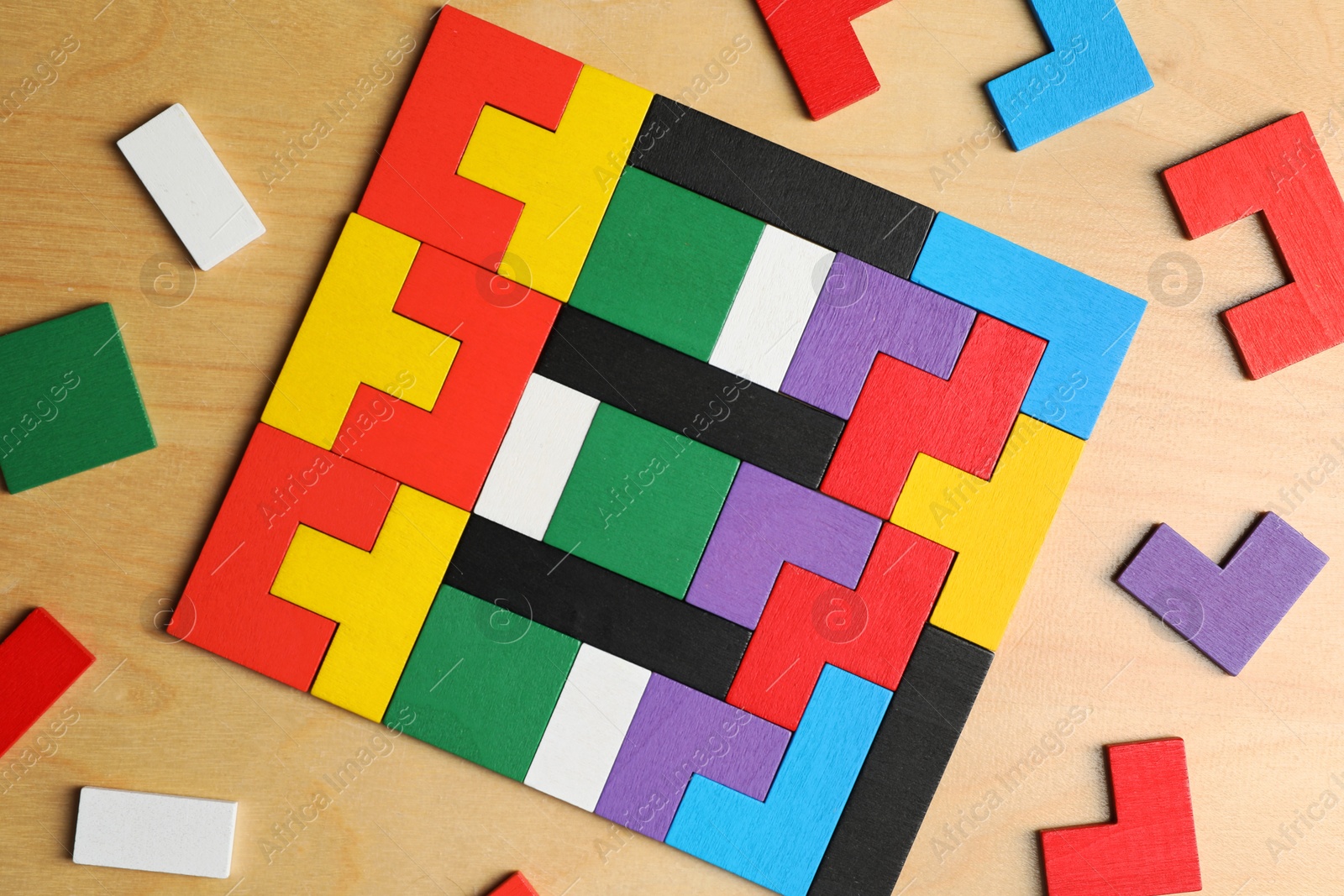 Photo of Colorful puzzle pieces on wooden table, flat lay