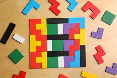 Photo of Colorful puzzle pieces on wooden table, flat lay