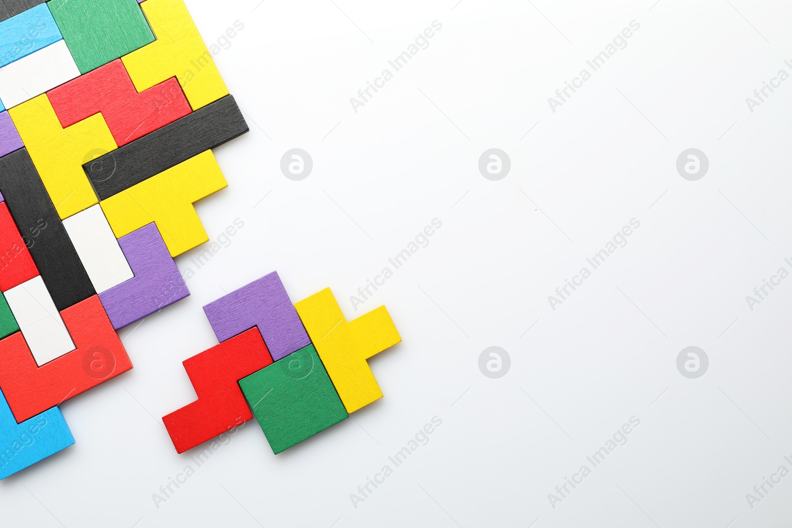 Photo of Colorful wooden puzzle pieces on white background, top view. Space for text