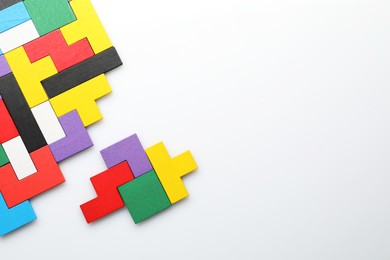 Photo of Colorful wooden puzzle pieces on white background, top view. Space for text