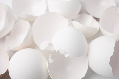 Photo of Pieces of broken eggshells on white background, closeup