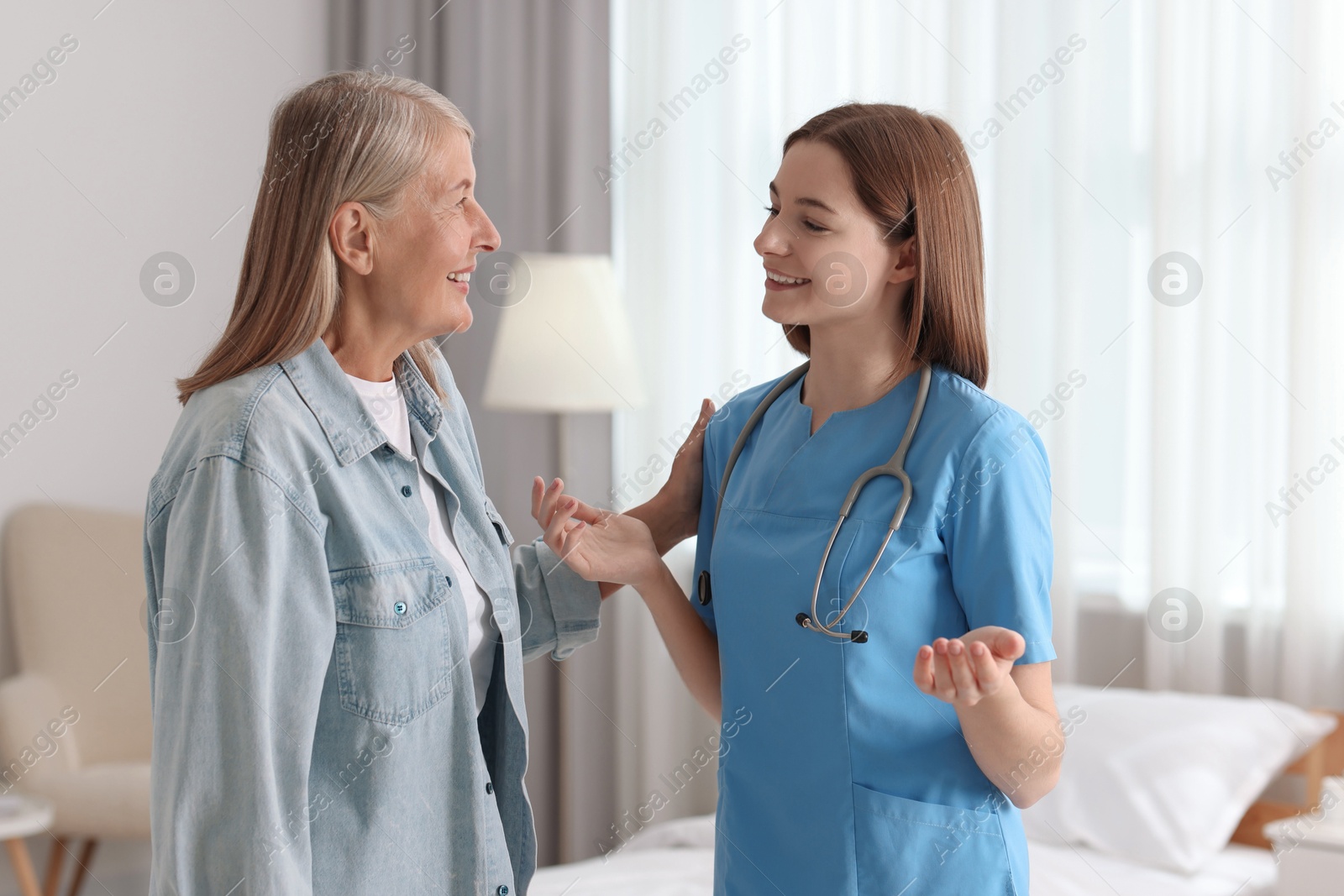 Photo of Young healthcare worker consulting senior patient indoors