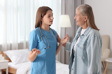 Photo of Young healthcare worker consulting senior patient indoors