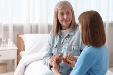 Photo of Healthcare worker supporting senior patient indoors. Space for text