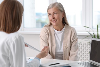 Smiling patient having appointment with healthcare worker in hospital