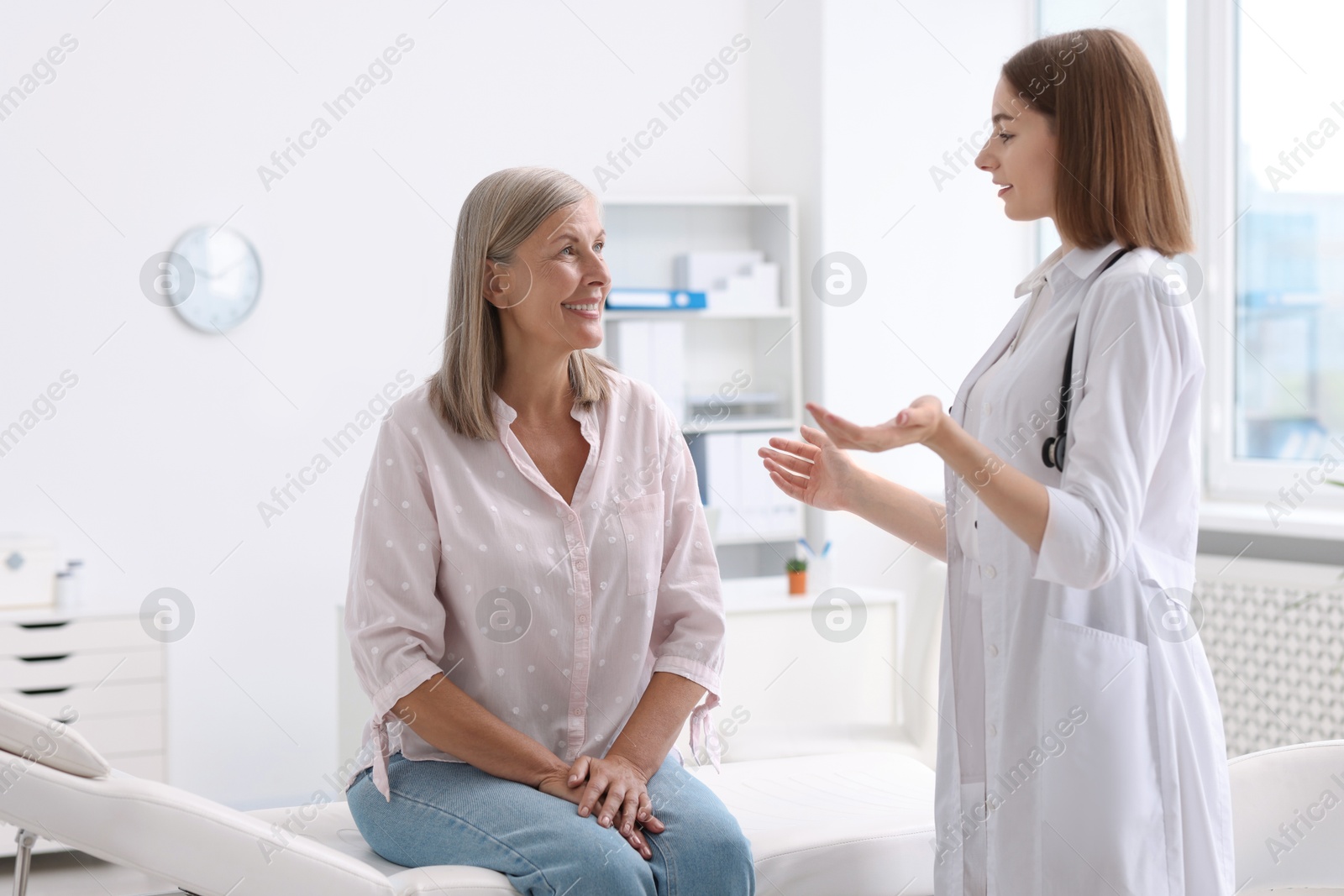 Photo of Young healthcare worker consulting senior patient in hospital