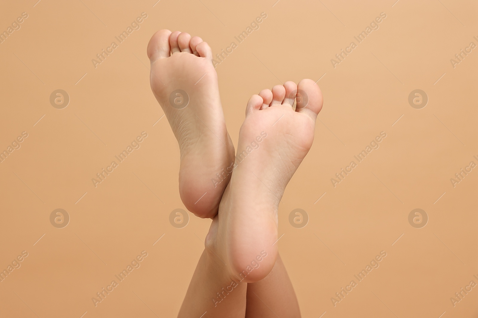 Photo of Woman with smooth feet on beige background, closeup