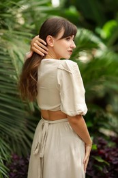 Beautiful woman posing in tropical forest, back view