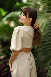 Beautiful woman posing in tropical forest, back view